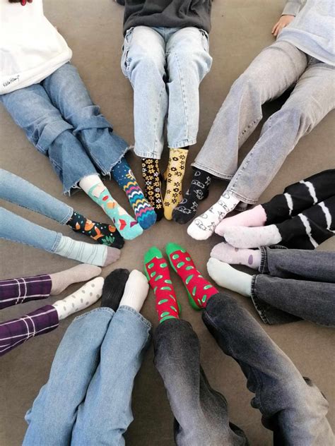 Obrázok ľudí s rôznymi farebnými ponožkami, symbolizujúci Svetový deň Downovho syndrómu