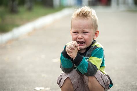 Smutné dieťa s dažďovými kvapkami na okne