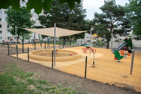 Školské ihrisko s deťmi hrajúcimi sa na hojdačkách a šmýkačke