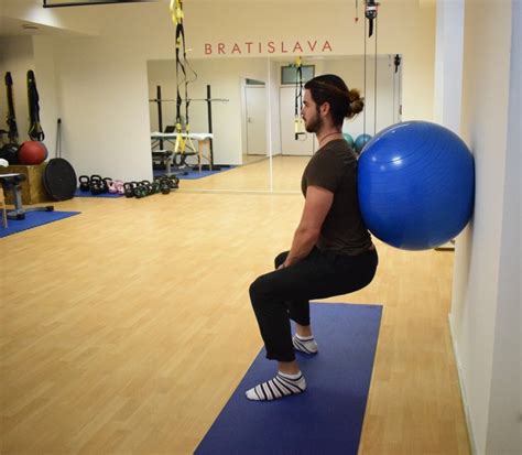 Žena robí drepy s fitloptou