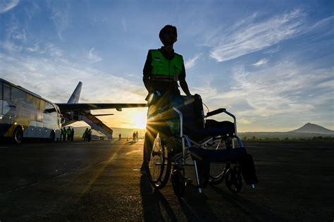 Ilustrácia osoby na invalidnom vozíku nastupujúcej do upraveného automobilu.