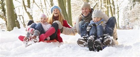 Rodina sa sánkuje na zasneženom kopci