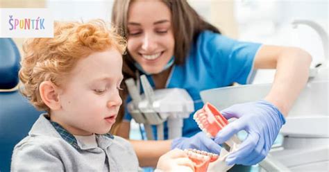 dieťa sedí u zubára v lone rodiča