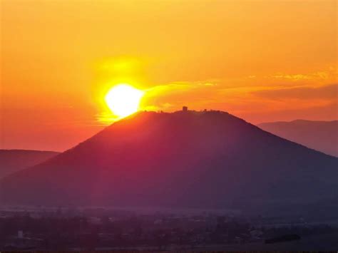 obrázok páru, ktorý sa drží za ruky a pozerá na východ slnka